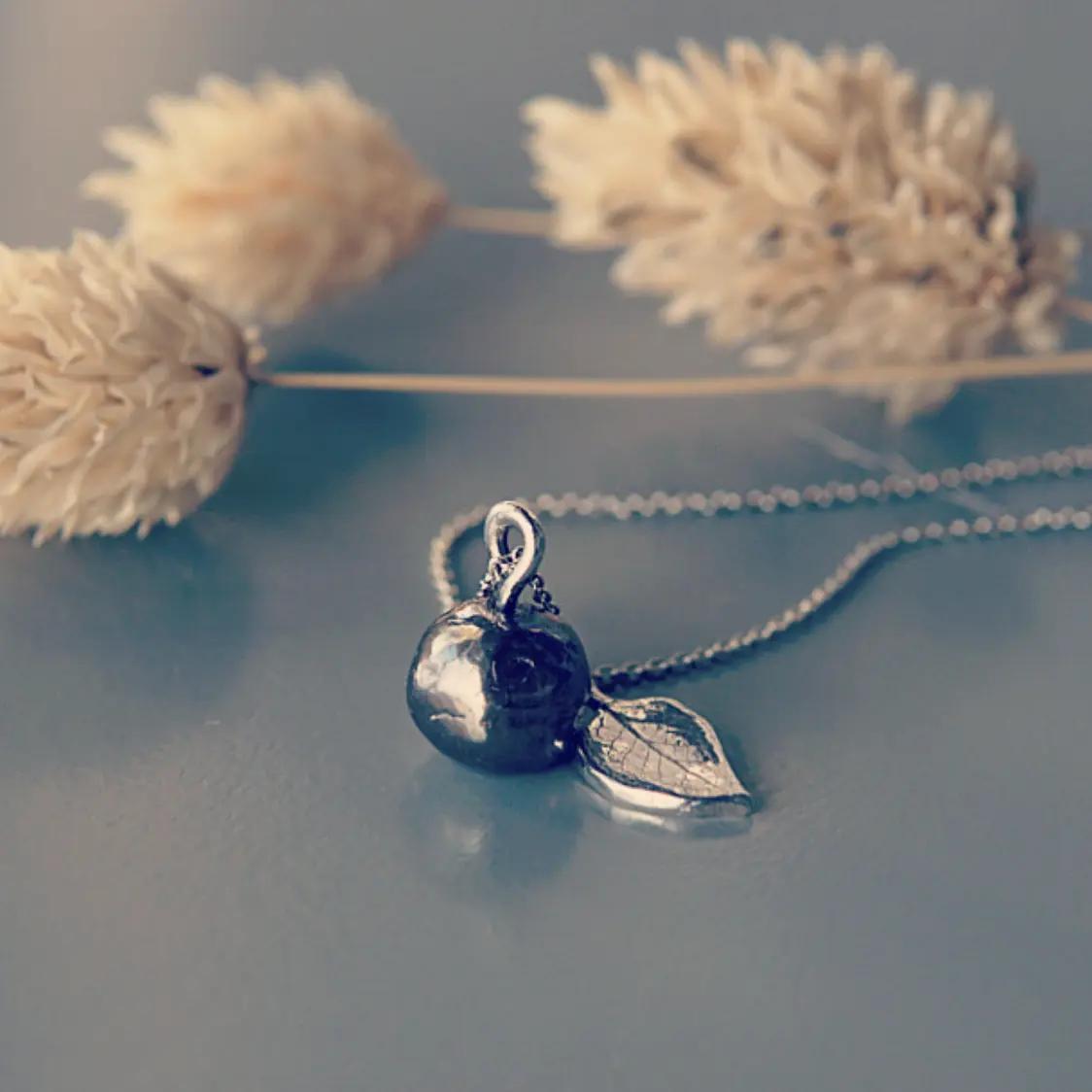 halsband i form av ett blåbär och blad i silver