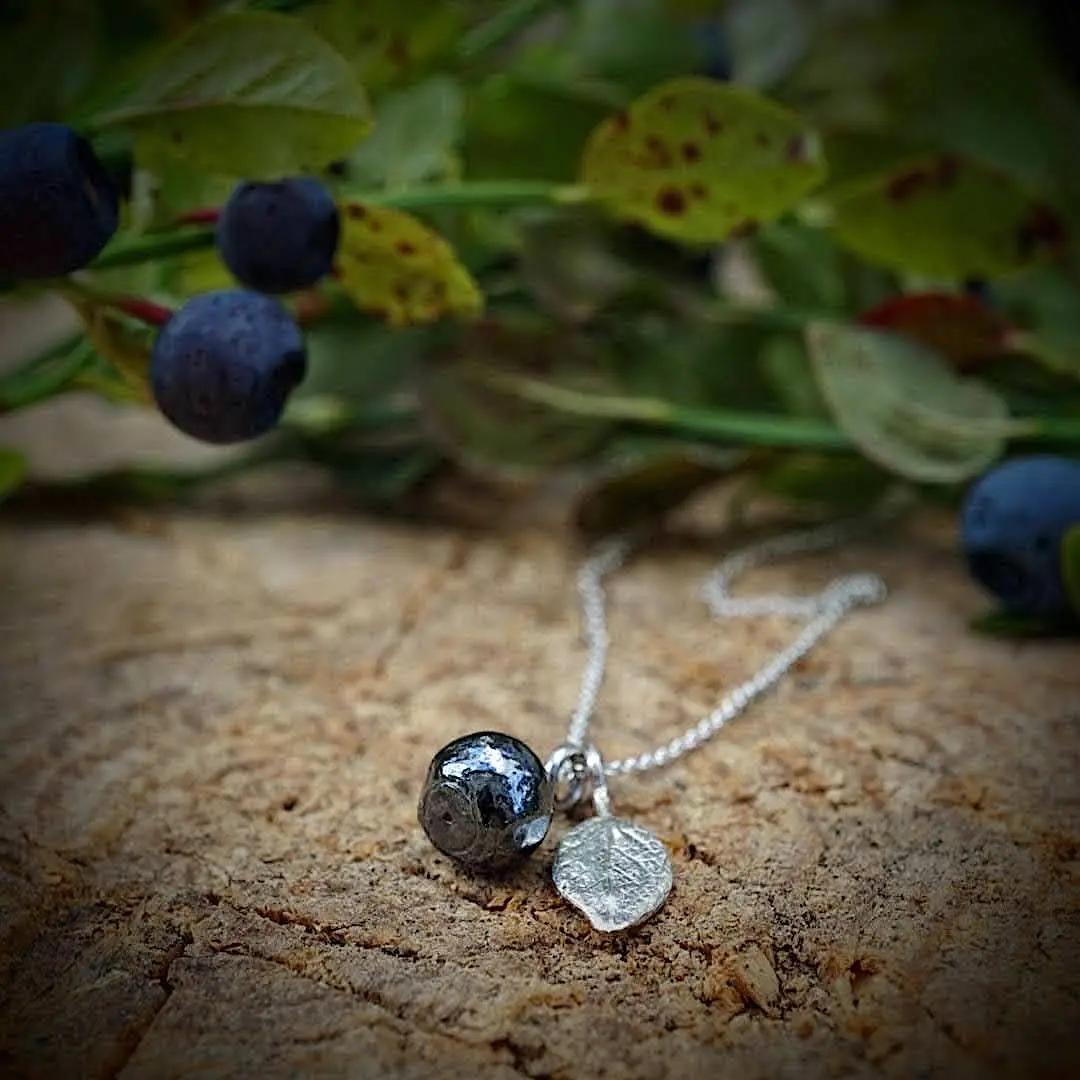 silverhalsband med ett blåbär och ett blad